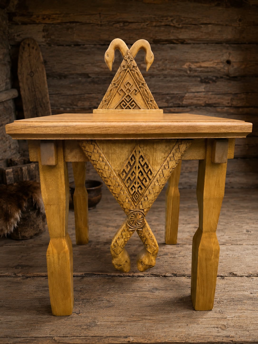 Hand-carved oak altar: a triangular structure with swans at the crest and serpents on the pendant. Photographed indoors.